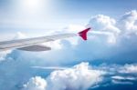 Cloudy Sky And Red Airplane Wing As Seen Through Window On Aircr Stock Photo