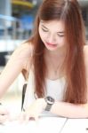 Portrait Of Thai Adult Beautiful Girl Write A Book And Smile In University Stock Photo