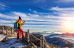 Young Woman Hiker Taking Photo With Smartphone On Mountains Peak In Winter Stock Photo