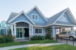 Bright Blue House In Sunlght With Colorful Poppies And Some Grac Stock Photo