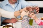 Family Toasting Water Glasses In Celebration Stock Photo