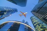 Passenger Jet Airplane Flies Above Skyscrapers Stock Photo