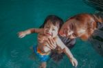 The Kid And Mom Play Together In The Pool Stock Photo