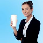 Cheerful Business Lady Holding Beverage Stock Photo