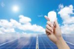 Solar Energy Panels And Light Bulb In Hand Stock Photo