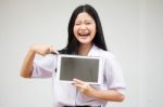 Portrait Of Thai High School Student Uniform Beautiful Girl Using Her Tablet Stock Photo