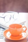 Laptop With Coffee Cup And Notepad On Desk Stock Photo