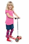 Little Girl Enjoying Her Toy Scooter Ride Stock Photo