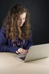 Teen Sitting At Table With A Laptop Stock Photo