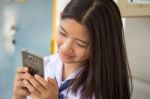 Portrait Of Thai Student Teen Beautiful Girl Using Her Phone And Smile Stock Photo