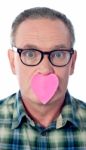 aged man with heart over his mouth Stock Photo