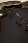 Eyeglasses With Magnifying Glass On Dark Surface With Books Stock Photo