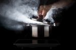 Hand Of Chef Open Hot Stream Pot With Beautiful Studio Lighting Against Black Background Use For People Cooking Food And Water Boiled In Kitchen Room Stock Photo