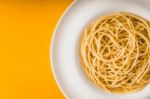 Spaghetti  On The White Plate On The Yellow Background Top View Stock Photo