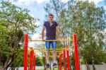 Young Man Is Practicing On A Horizontal Bar Stock Photo