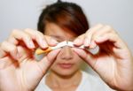 Woman Breaking A Cigarette Stock Photo