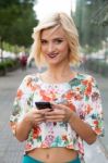 Woman In The Street Browsing A Smart Phone Stock Photo