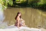 Young Beautiful Brunette Sitting Near The Lake Stock Photo