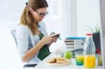 Pretty Young Woman Eating An Apple And Working At Home Stock Photo