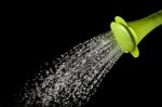 Green Watering Can Pouring Water With High Speed Shutter Isolated On Black Stock Photo