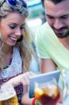 Couple Of Young Students Using A Digital Tablet In The Bar Stock Photo