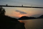 People Walking Across The Bridge With Sunset Stock Photo