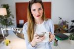 Beautiful Young Woman Using Her Mobile Phone In The Office Stock Photo