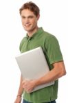 Smiling Young Man Holding Laptop Stock Photo