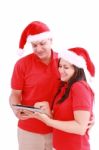 Christmas Couple Looking A Tablet Computer Stock Photo