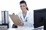 Smiling Young Doctor With Clipboard In Hand Looking At The Camera Stock Photo