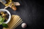 Spaghetti, Olives And Olive Oil On The Black Stone Table Stock Photo