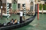 Gondolier Ferrying People In Venice Stock Photo