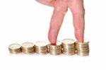 Fingers Walking Up On Stacks Of One Pound Coins Stock Photo