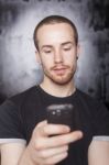 Young Male Holding Smartphone Stock Photo