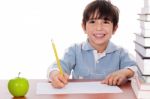 School Boy Doing His Homework With An Apple Beside Him Stock Photo