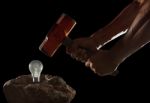 Abstract Of Hand Holding Heavy Hammer To Breaking Light Bulb On Stock Photo