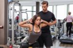 Woman With Personal Trainer  In Gym Stock Photo