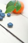 Tangerine And Blueberry On White Table Stock Photo