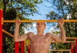 Young Man Is Practicing On A Horizontal Bar Stock Photo