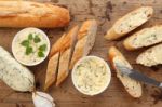 Baguette With Herb Butter And Rosemary Thyme On Rustic Wooden Background Stock Photo