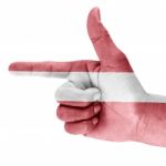 Latvia Flag On Shooting Hand Stock Photo