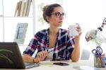 Beautiful Young Woman Drinking Coffee In Her Office Stock Photo