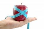 Red Apple With Tape In Hand Stock Photo