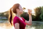 Sporty Woman Drinking Water On Sunlight Stock Photo