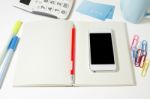 Work Table With Blank Notebook And Phone Stock Photo