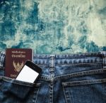 Blue Jeans With Cell Phone And Passport In A Pocket Background Stock Photo