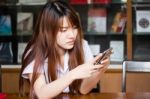 Portrait Of Thai Adult Student University Uniform Beautiful Girl Using Her Smart Phone Stock Photo