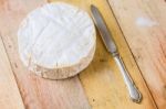 Camembert Cheese And Vintage Knife On Wooden Table Stock Photo