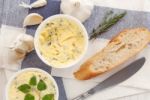 Baguette With Herb Butter And Rosemary Thyme On Rustic Wooden Background Stock Photo