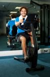 Guy Working Out In Exercise Bike Stock Photo